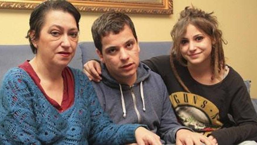 Víctor Díaz, el joven de Gandia que está batallando para recuperar su derecho a voto, entre su madre, Marisa, y su hermana, Mónica, en la vivienda familiar esta semana.