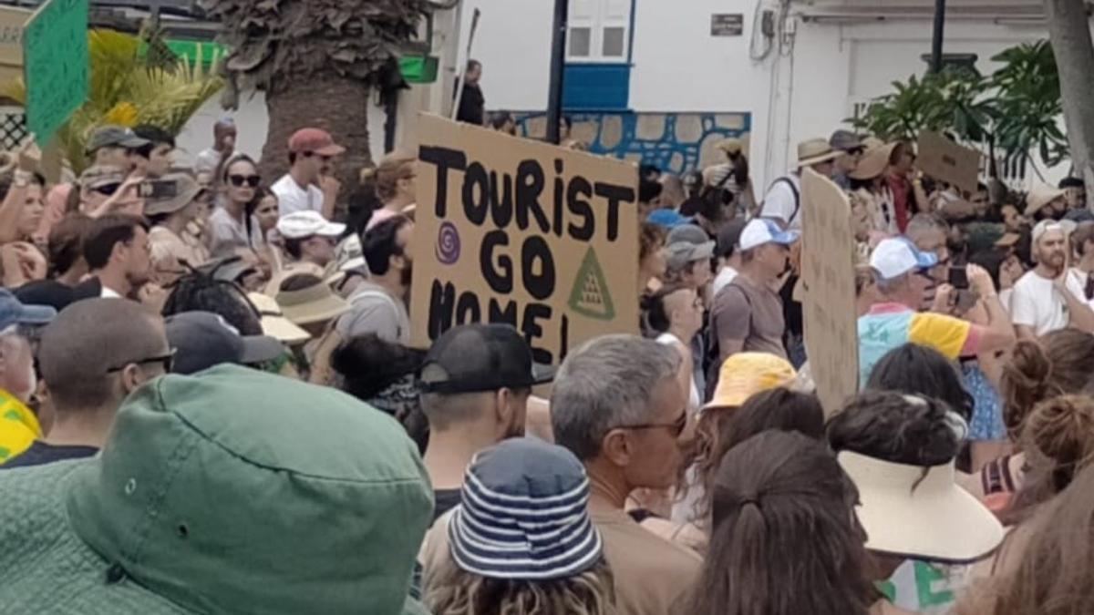 Manifestantes con carteles en contra del turismo en Canarias.