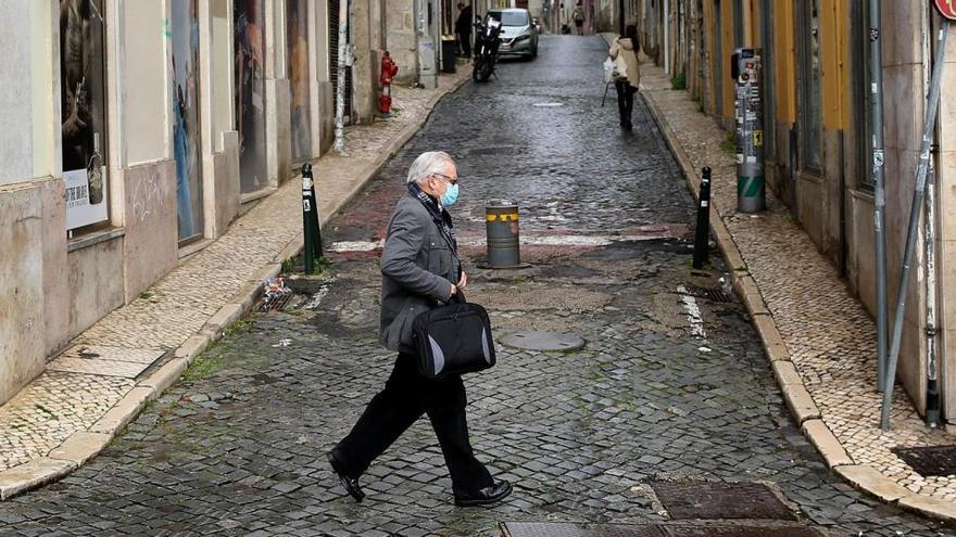 Un hombre con mascarilla pasea por Lisboa.