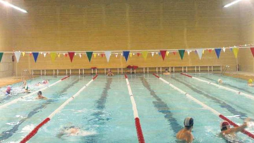 Ciudadanos practican natación en las instalaciones de la piscina climatizada.