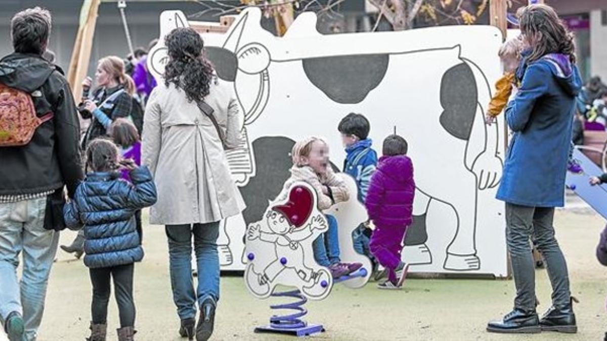 Varias familias con niños de corta edad, en un parque infantil de Barcelona.