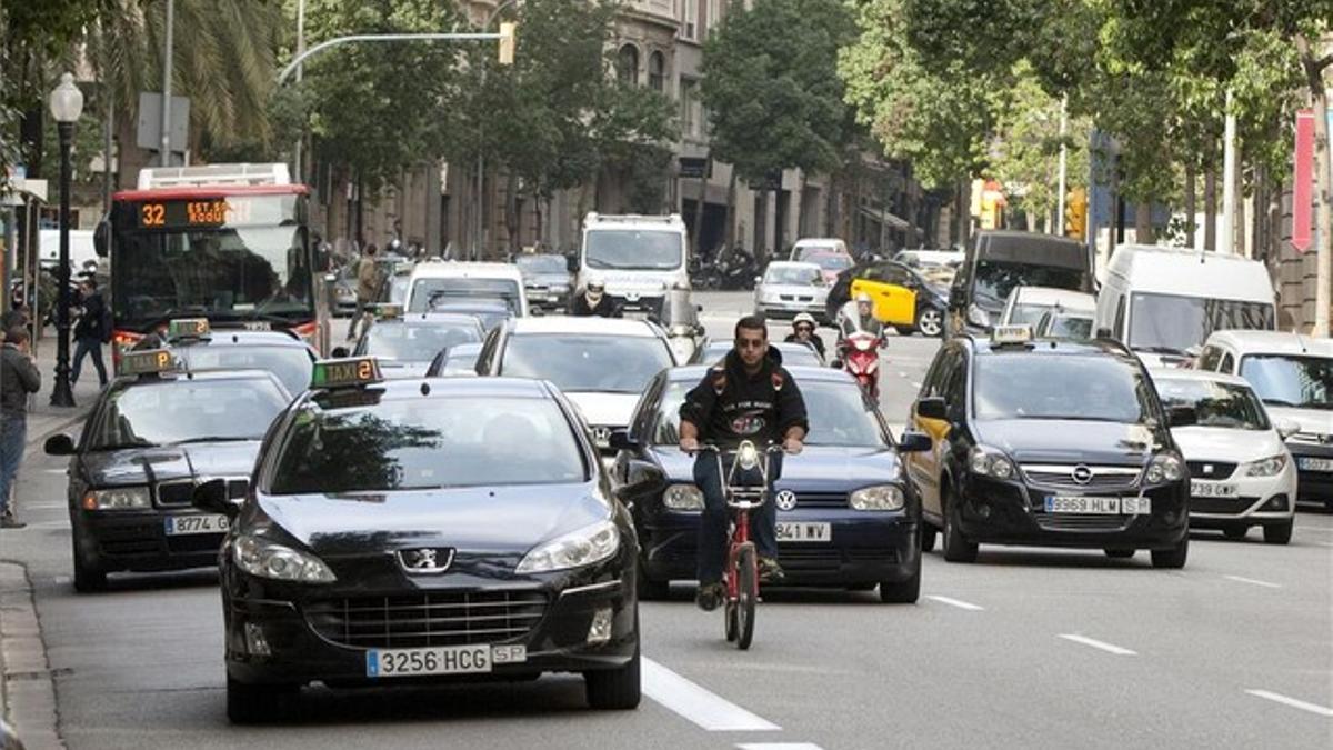 Un usuario del Bicing intenta abrirse paso en el denso tráfico diario de la calle de Balmes, justo antes de llegar a la Diagonal, el pasado noviembre.