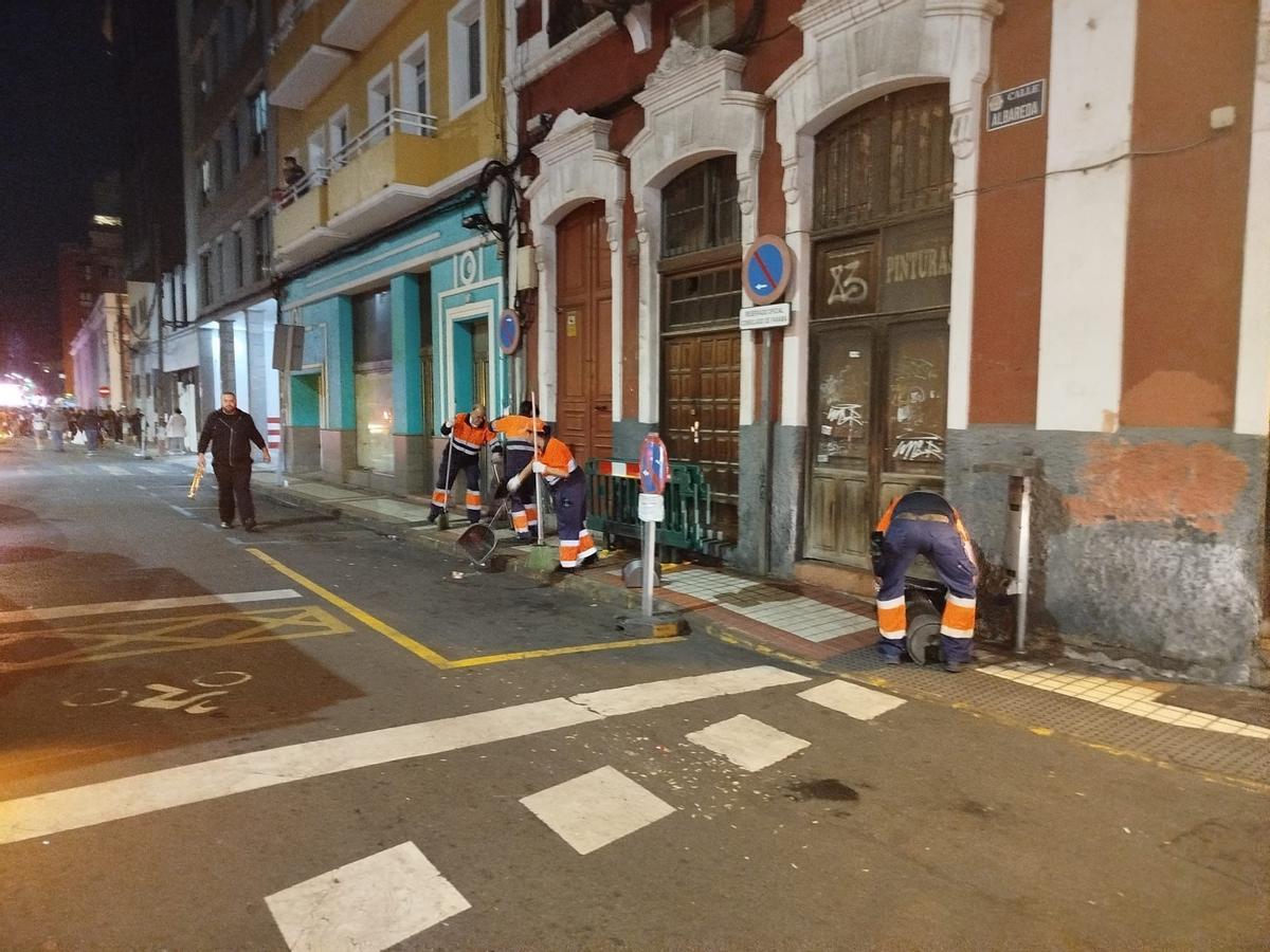 Barrenderos limpian una calle del Puerto durante una noche de Carnaval.