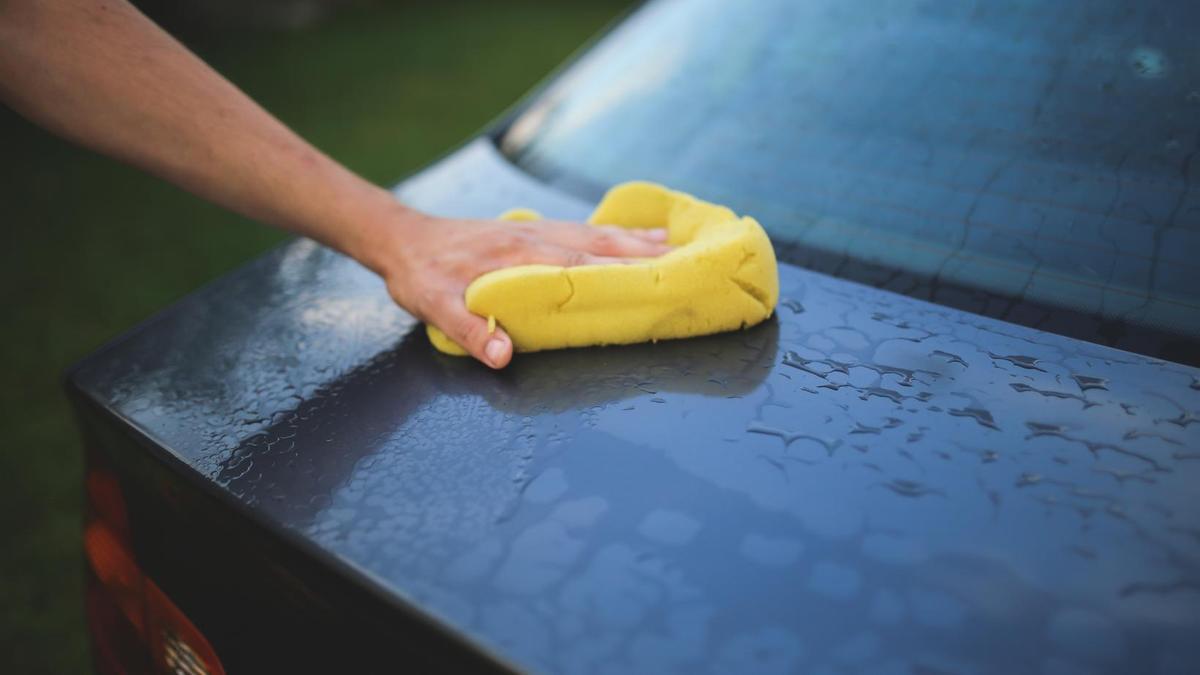 Una persona limpia su coche.