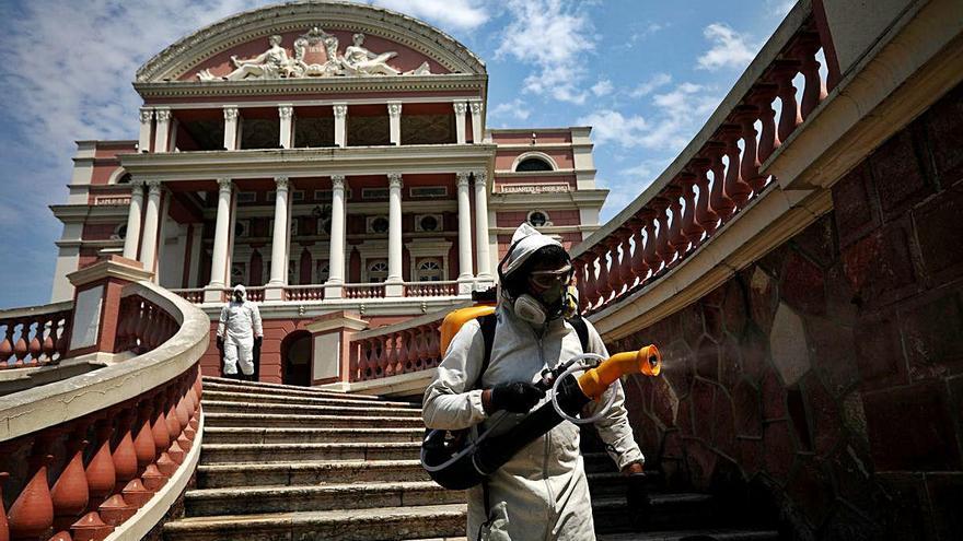 Un operari desinfecta l&#039;exterior del teatre Amazones, a la localitat brasilera de Manaus