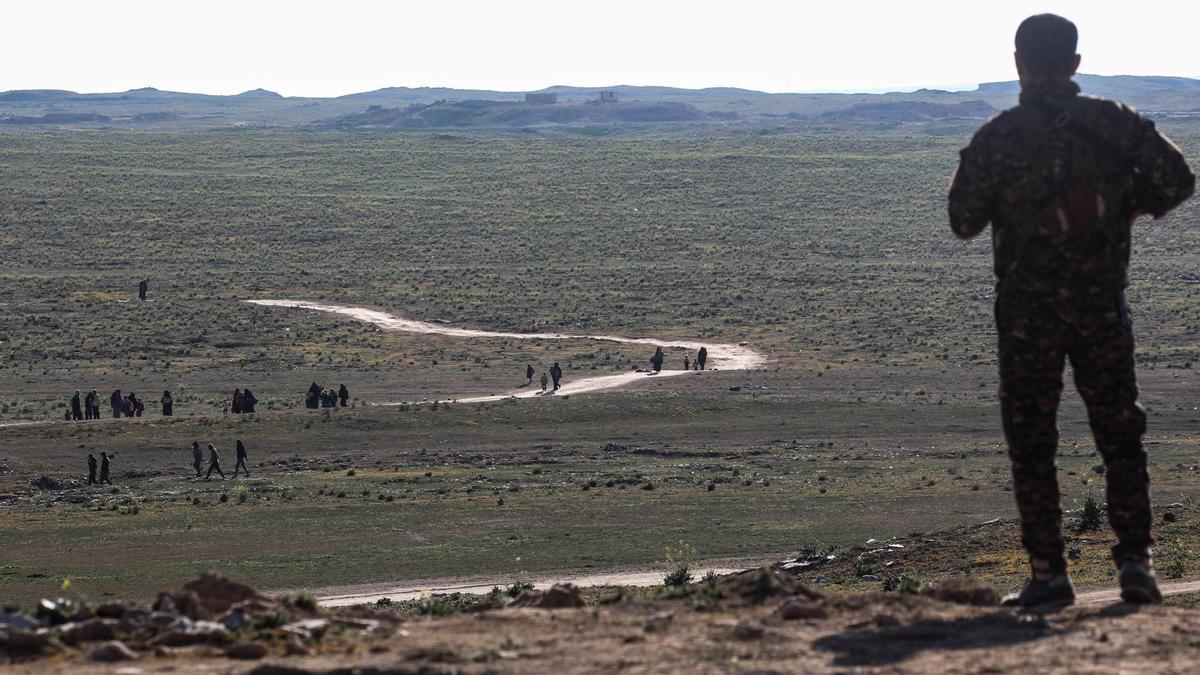 Imagen de archivo de un combatiente de las FDS que observa cómo los civiles huyen de la aldea de Baghouz, controlada por Estado Islámico, en la provincia oriental siria de Deir Ezzor.