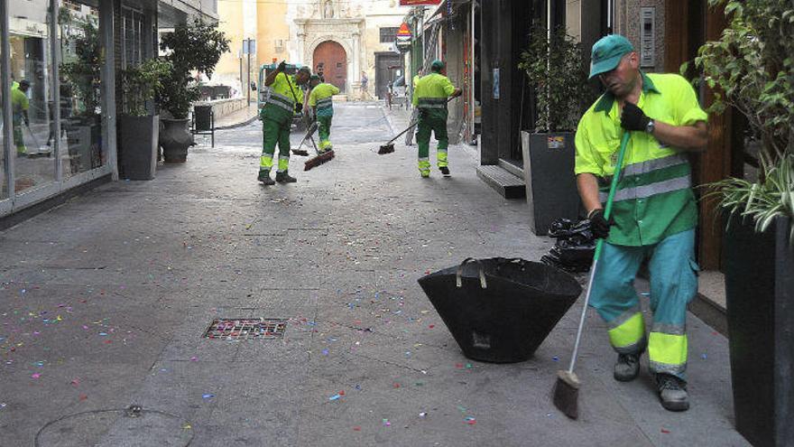 Operarios de la empresa Urbaser limpiando una calle del centro de la ciudad tras la Nit de la Roà