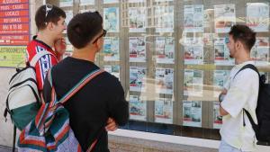 Jóvenes delante del escaparate de una inmobiliaria.