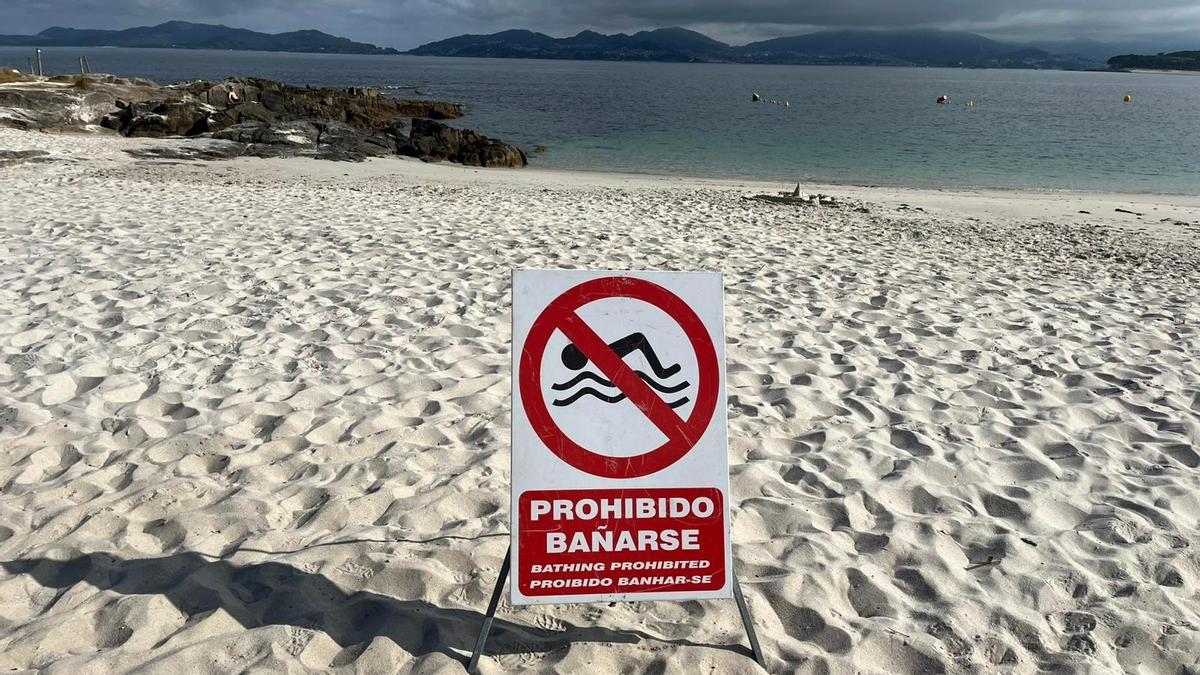 El cartel con la prohibición de baño en A Fontaíña este viernes a primera hora.