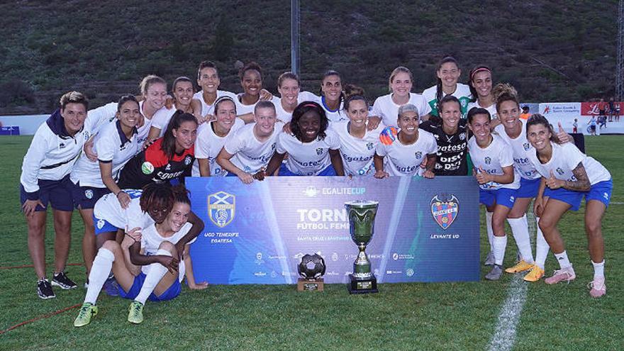 La plantilla del Granadilla Egatesa posa junto a la copa de campeonas de la Egalité Cup-Trofeo Isla de Tenerife y la distinción de MVP de Raissa.