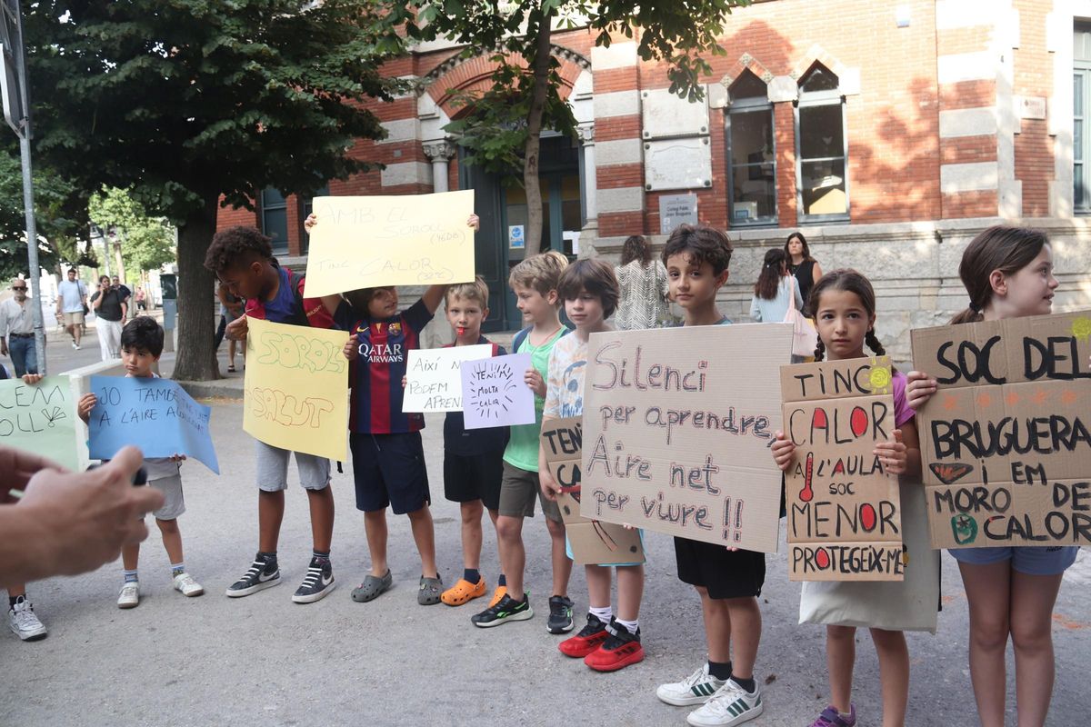 Alumnes de l'escola Joan Bruguera de Girona aguanten pancartes reivindicatives per l'excés de soroll i calor.