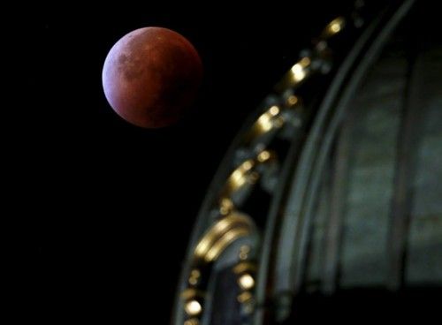 A supermoon rises in the sky next to the Swiss Parliament building in Bern