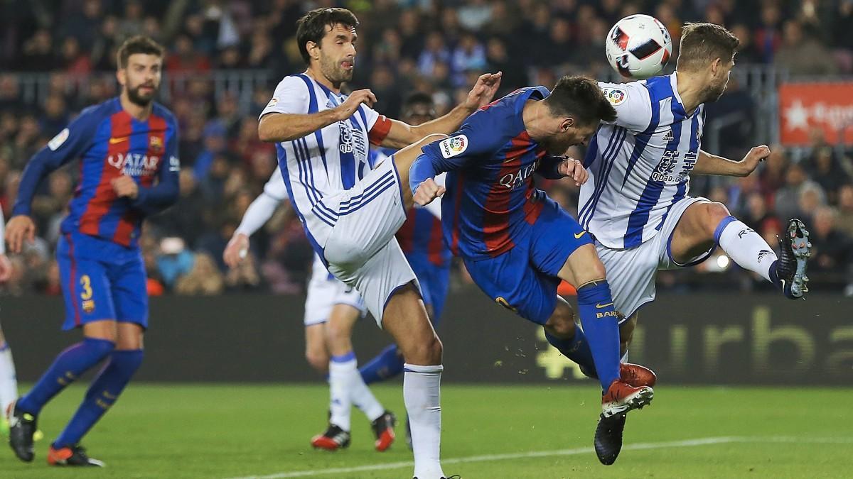 Xabi Prieto e Iñigo Martínez disputan un balón con Leo Messi