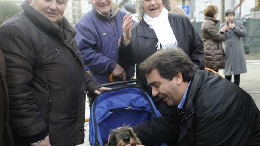 Negreira saluda en la pasada campaña electoral al perro secuestrado y a su dueña, a la izquierda. / c. pardellas