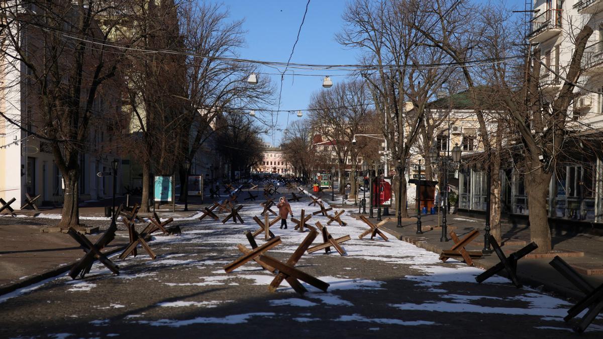 Una mujer camina entre barricadas por una calle de Odesa, en Ucrania.