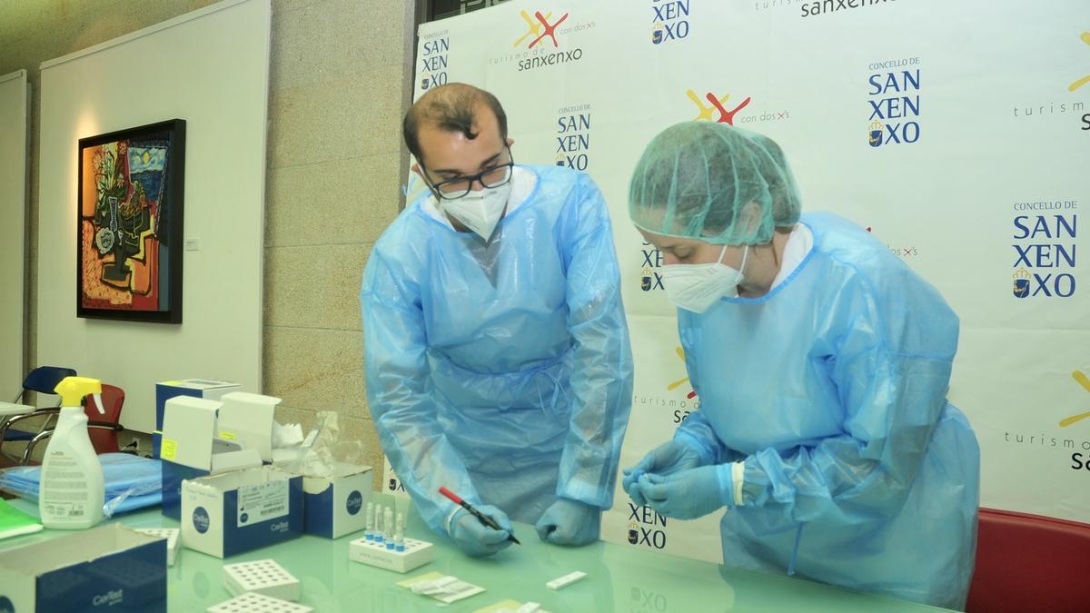 Dos profesionales etiquetando test de antígenos en el cribado que fue realizado la semana pasada en la Sala Nauta, en Sanxenxo