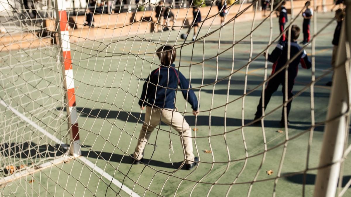 Archivo - Varios niños juegan al fútbol en el patio del Colegio Alameda de Osuna