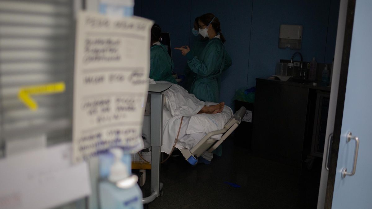 Personal sanitario visita a un paciente ingresado en la Unidad de Cuidados Intensivos.