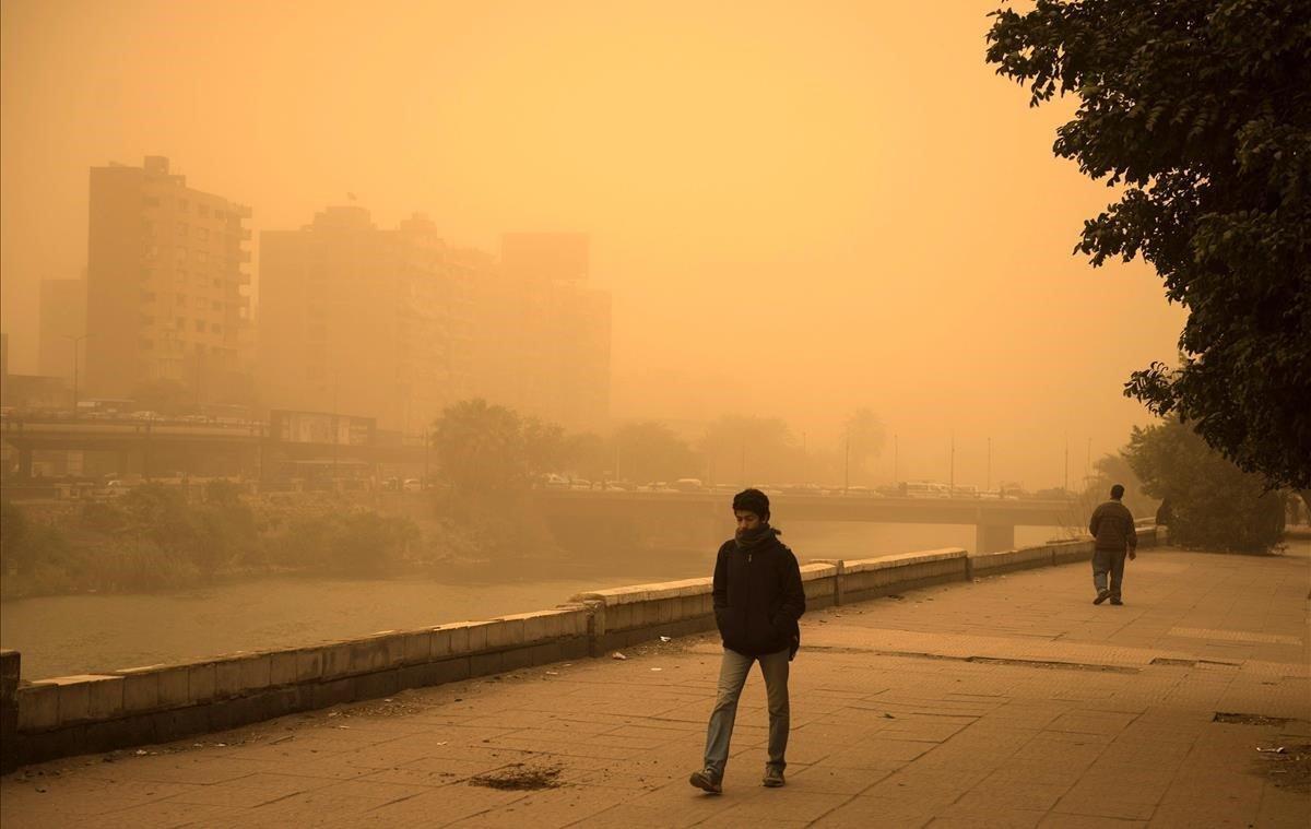 Un hombre sale a caminar durante una tormenta de arena en El Cairo. La tormenta ha provocado que varios zoos y parques hayan tenido que cerrar sus puertas al público. Los meteorólogos han pronosticado lluvia a partir de esta noche en la ciudad.