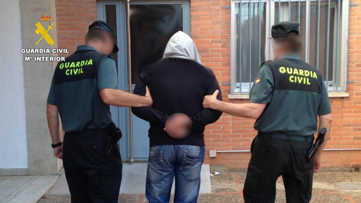 Dos agentes conducen detenido al autor del atraco, un conductor de camión uruguayo que hace la ruta Benavente-Galicia.