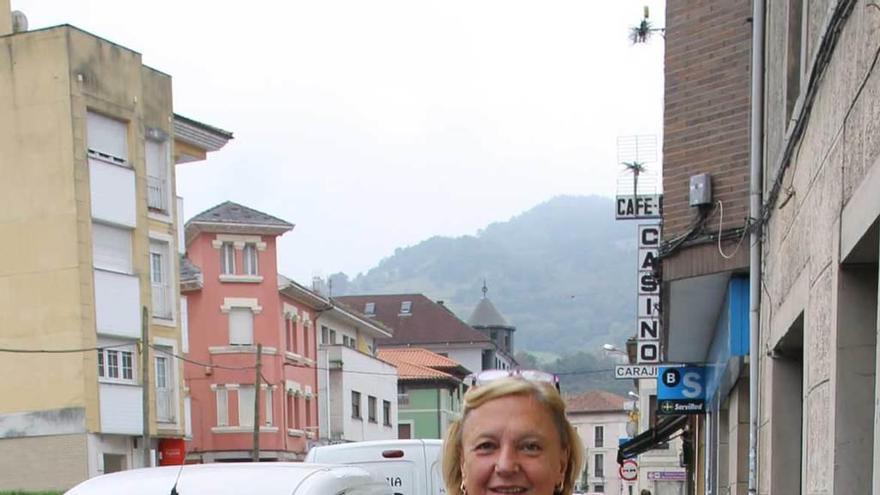 Ana Menéndez pasea por Cornellana. Al fondo, el letrero de su bar.