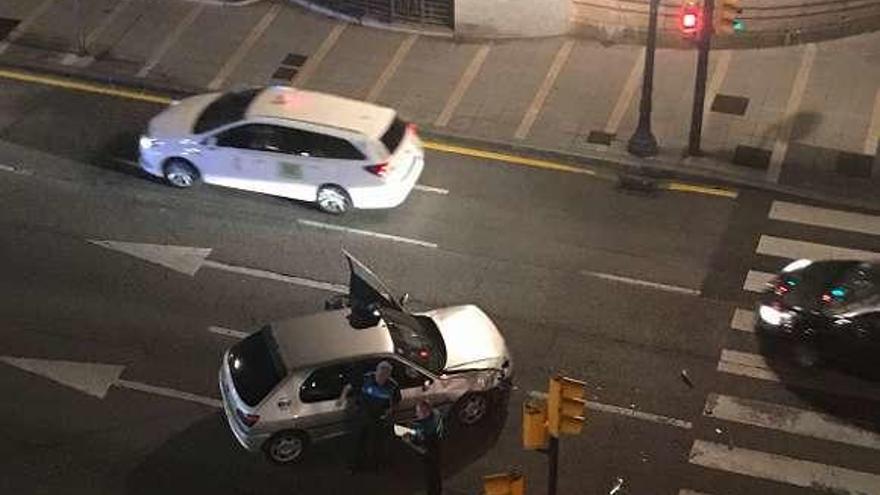 Dos agentes de la Policía Local examinan el vehículo abandonado.