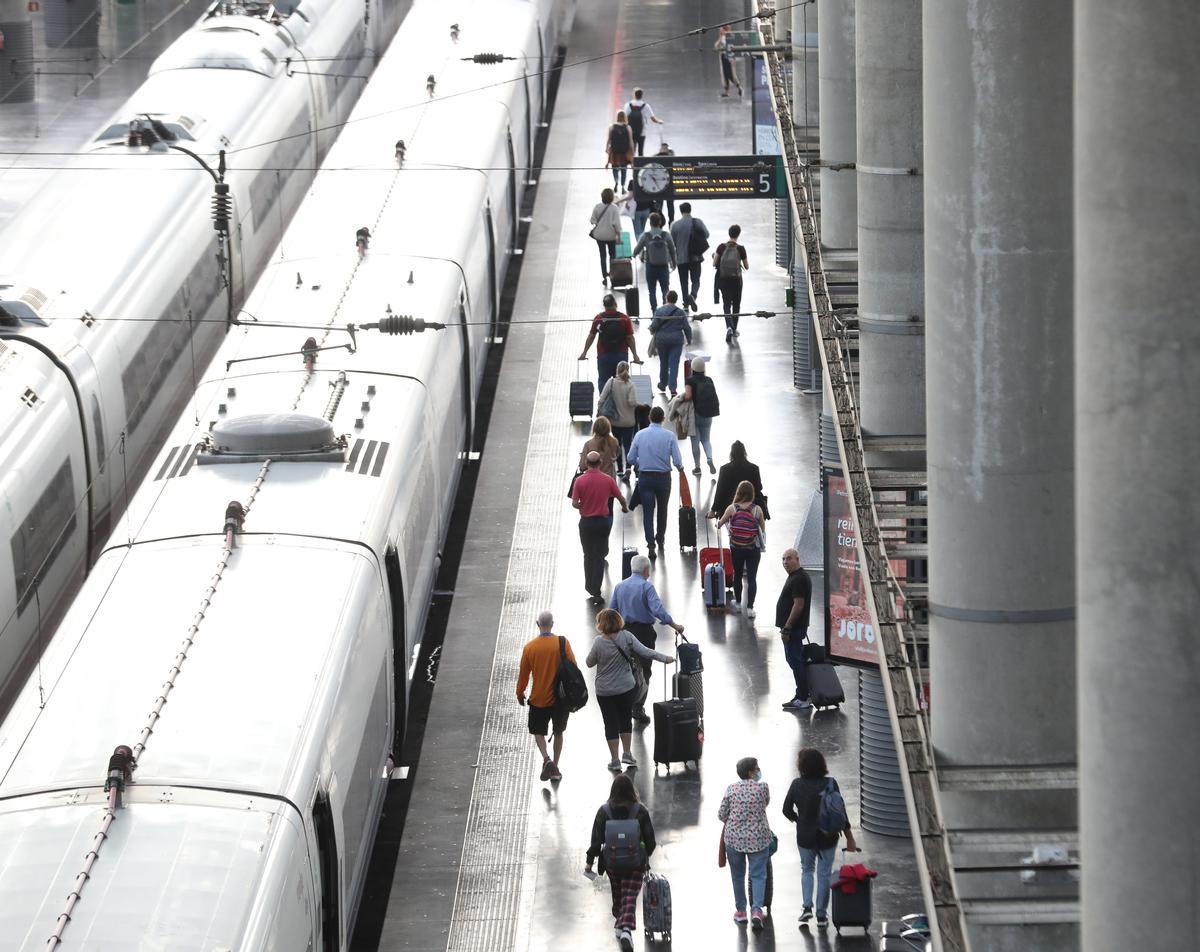 Archivo - Varios pasajeros con maletas en el andén de un tren en la estación de Puerta de Atocha