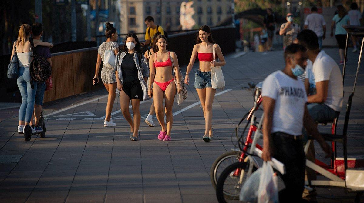 Varios jóvenes sin mascarilla o con ella mal puesta pasean por el centro de Barcelona, este miércoles 29 de julio.