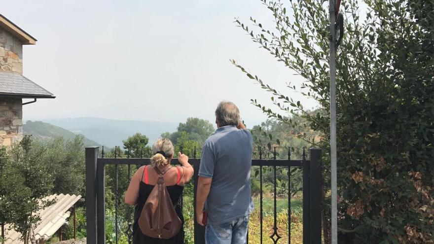 Dos personas observan el humo en Sanabria.