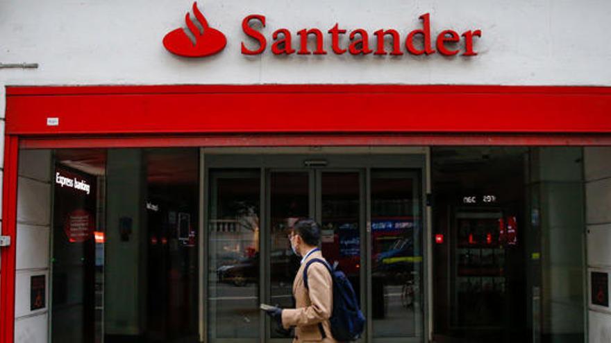 Un ciudadano camina delante de una oficina del Banco Santander.