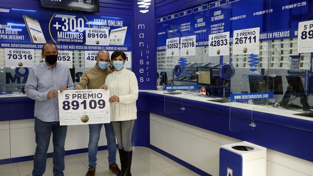 Los tres hermanos Sanchis posan con uno de los premios vendidos en su local, ayer.  | M.A.MONTESINOS