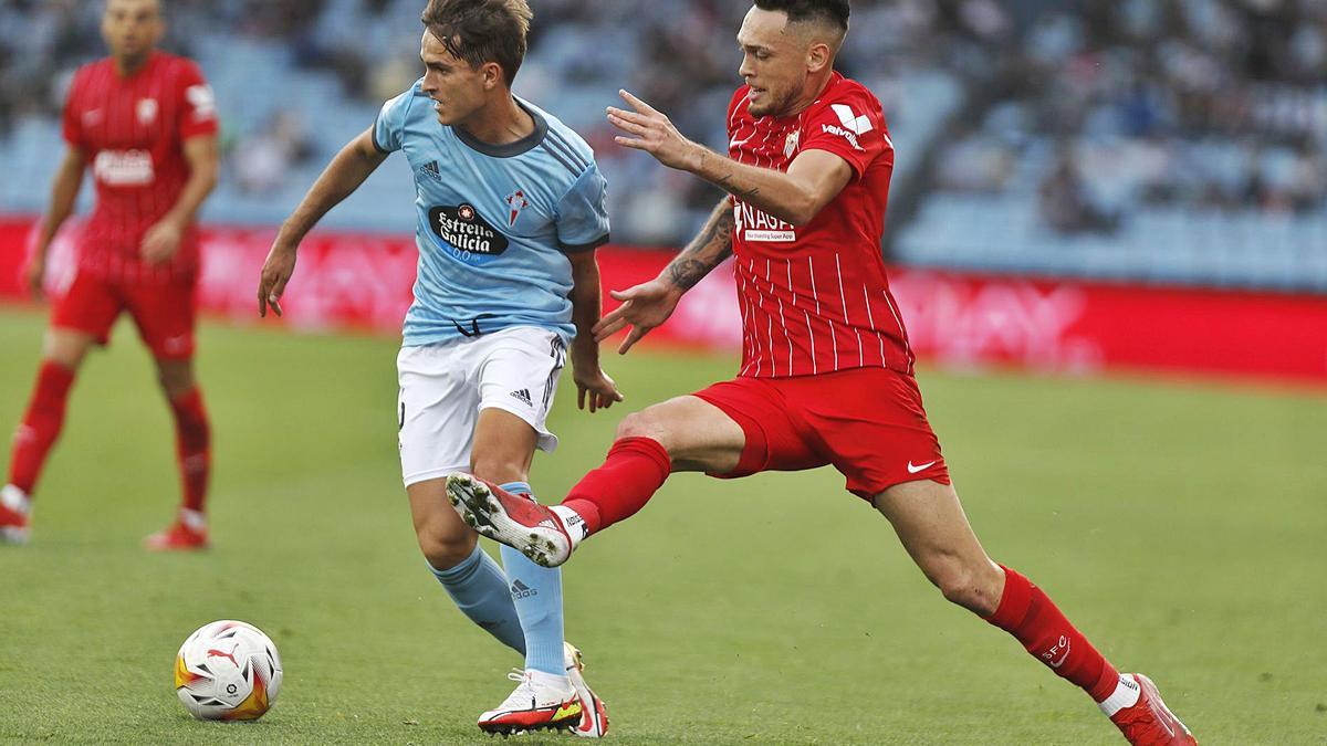 Denis Suárez conduce la pelota perseguido por el argentino del Sevilla Lucas Ocampos, ayer en Balaídos. // RICARDO GROBAS