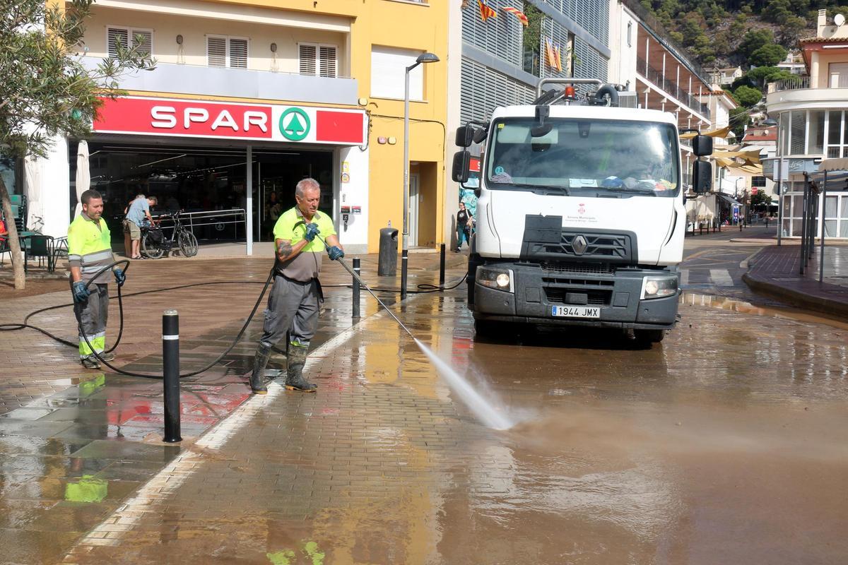 Les brigades municipals netejant amb aigua a pressió el fang en un dels carrers de l'Estartit