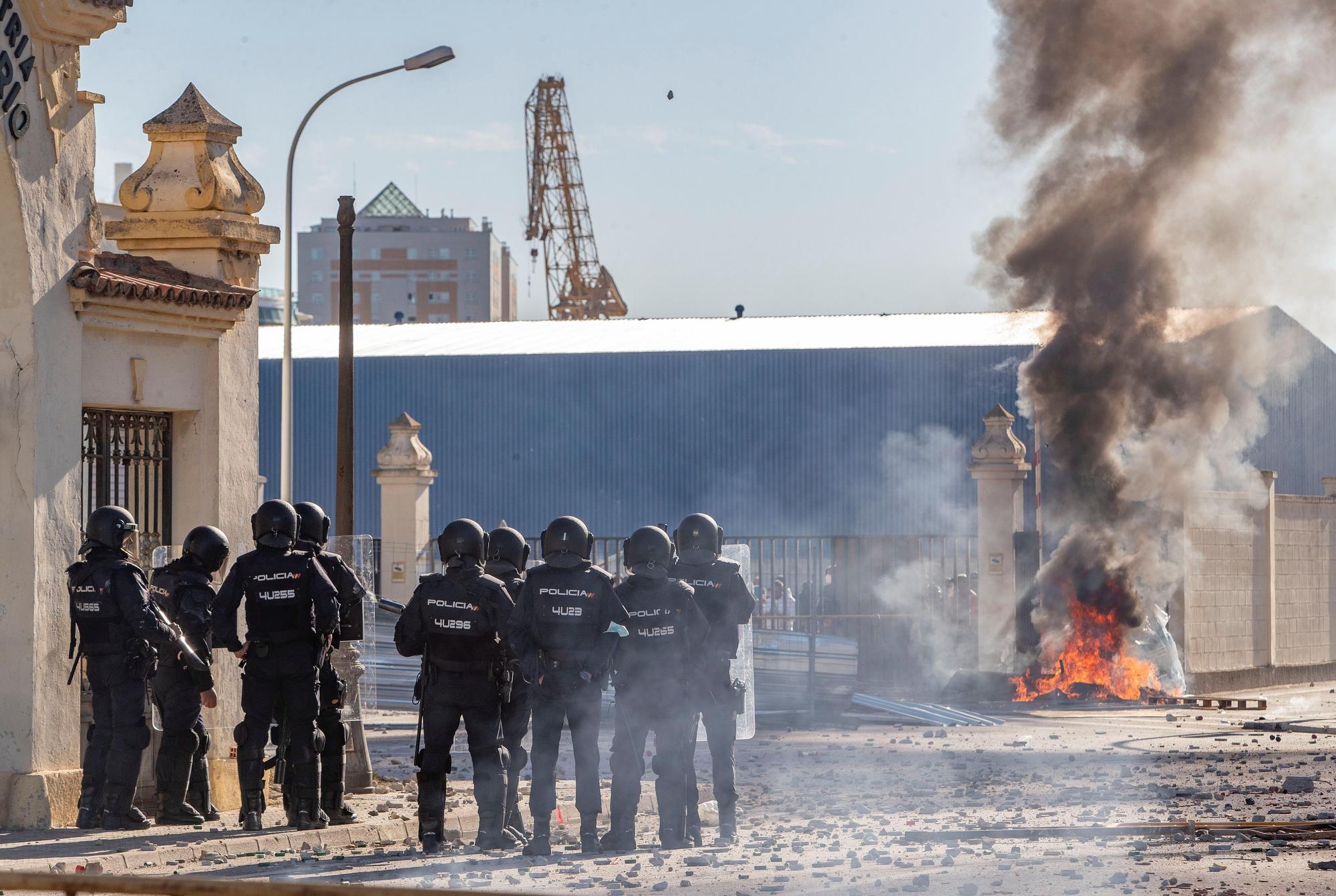 Un grupo de Policías antidisturbios ante los trabajadores del sector del metal que se manifiestan ese martes a la puerta de la factoría de Navantia de Cádiz.