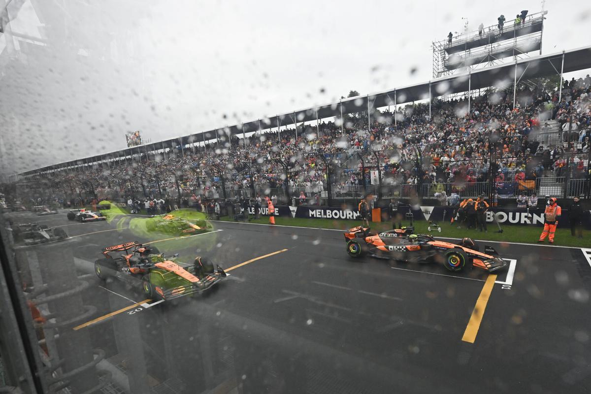 McLaren driver Lando Norris, right, of Britain and teammate Oscar Piastri of Australia wait on the starting grid ahead of the start of the Australian Formula One Grand Prix at Albert Park, in Melbourne, Australia, Sunday, March 16, 2025. (Tracey Nearmy/Pool Photo via AP). POOL PHOTO