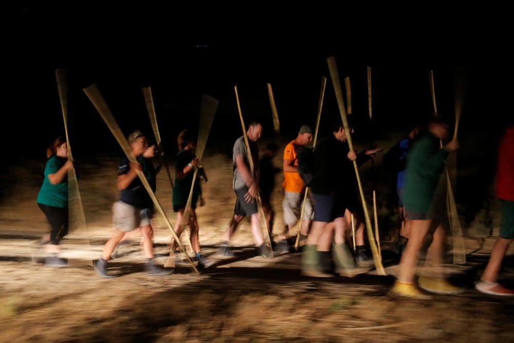 Volunteers hold canes before wading across the ...