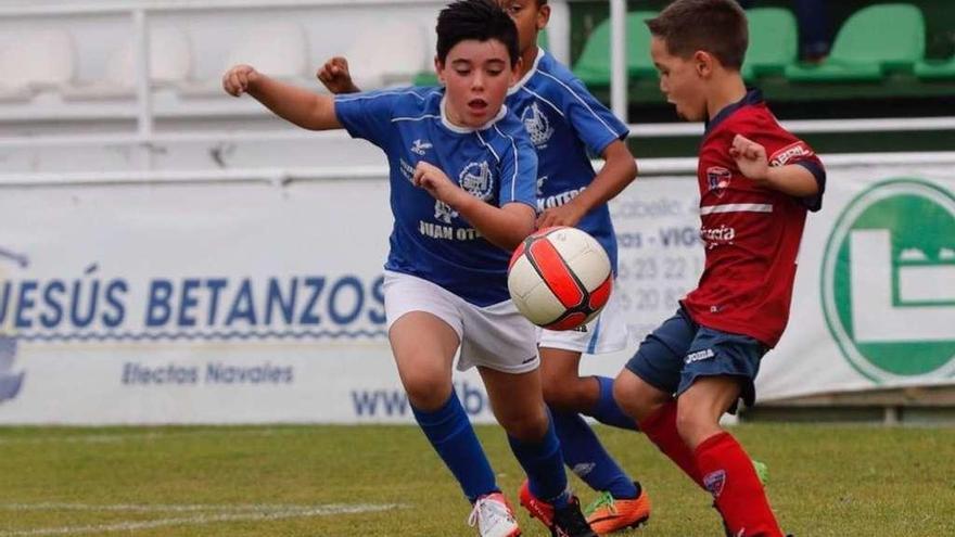 Dos jugadores del Santa Mariña y del La Guía disputan un balón en el campo de Coruxo durante un partido de ayer. // José Lores