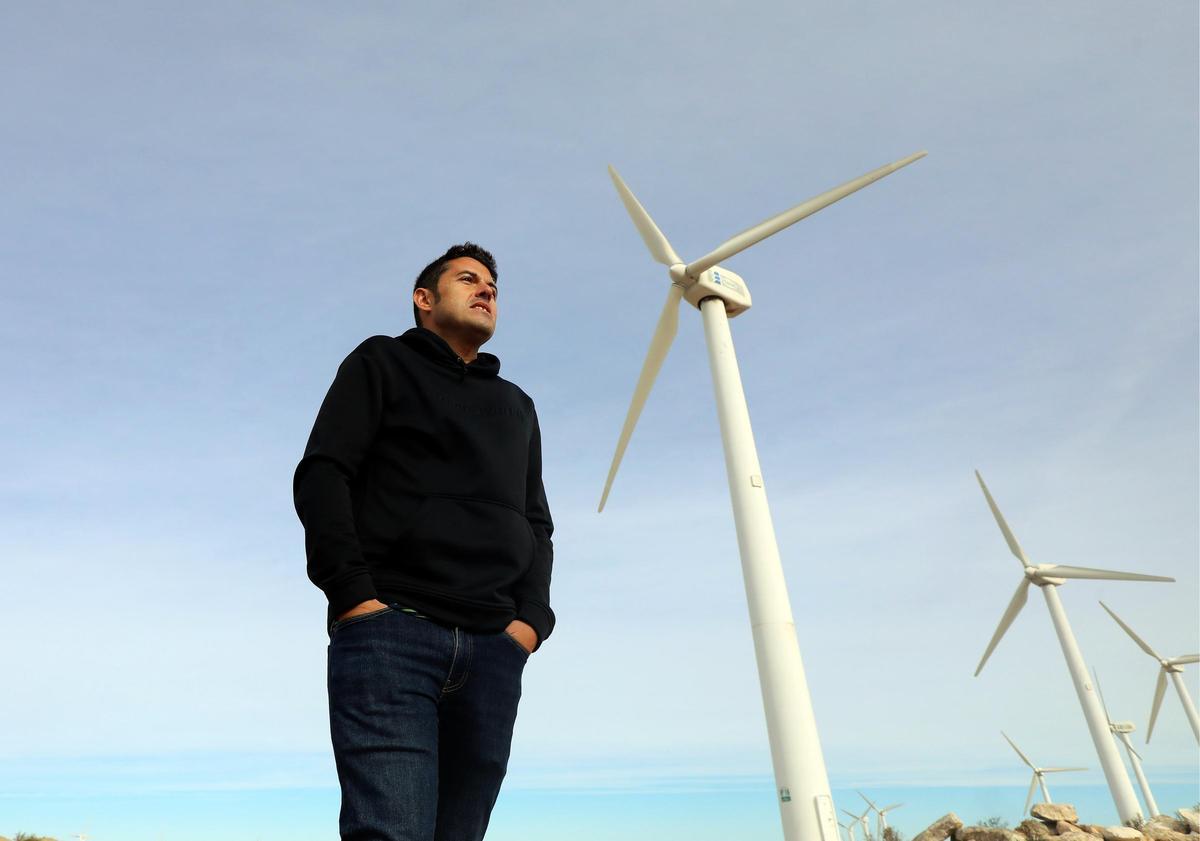 El alcalde de La Muela, Adirán Tello, junto a uno de los viejos aerogeneradores