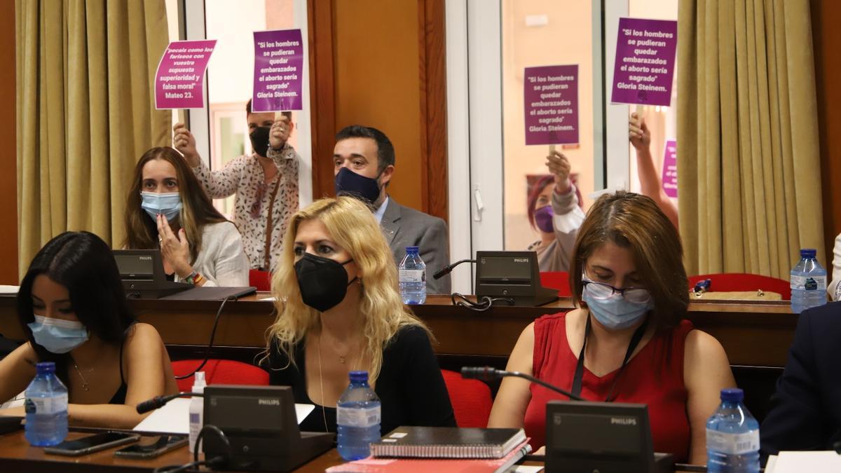 Varias mujeres han mostrado su apoyo a la moción para proteger a las mujeres que acuden a abortar con pancartas.