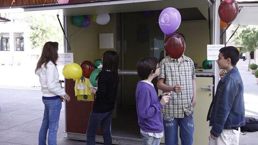 Niños recogen sus globos en la caseta de Manos Unidas.