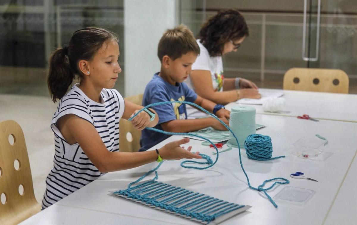 Clara, Lucas y Montse, hijos y madre, se afanan en acaba su bolso. | ALBA PRIETO