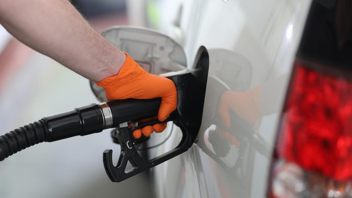 Ein Mann tankt seinen Wagen an einer Tankstelle.