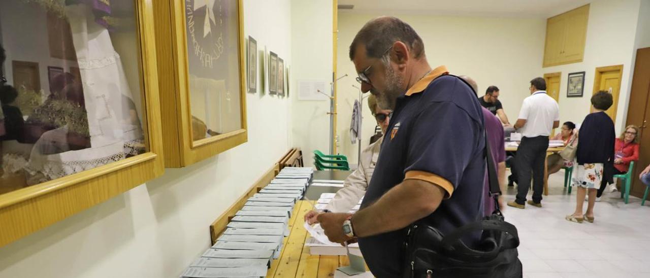 Un elector recoge papeletas y sobres de la formación a la que quiere votar, en una mesa electoral en mayo de 2019.