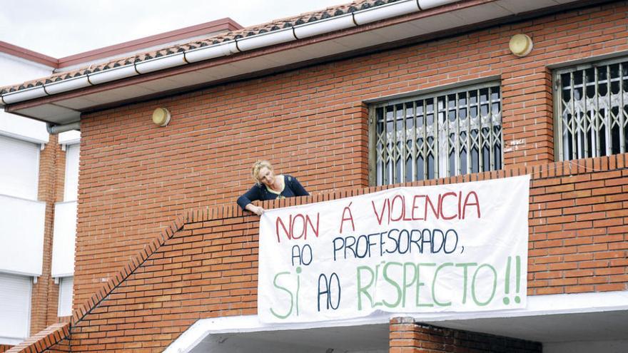 Una trabajadora del centro educativo, ayer, con la pancarta contra la violencia. // Brais Lorenzo