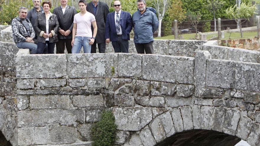 Representantes del Novo Proxecto, ayer en el puente románico de A Ramallosa, símbolo del patrimonio histórico y cultural del Val Miñor, en el que confluyen los tres concellos y que inspira su logotipo.  // José Lores