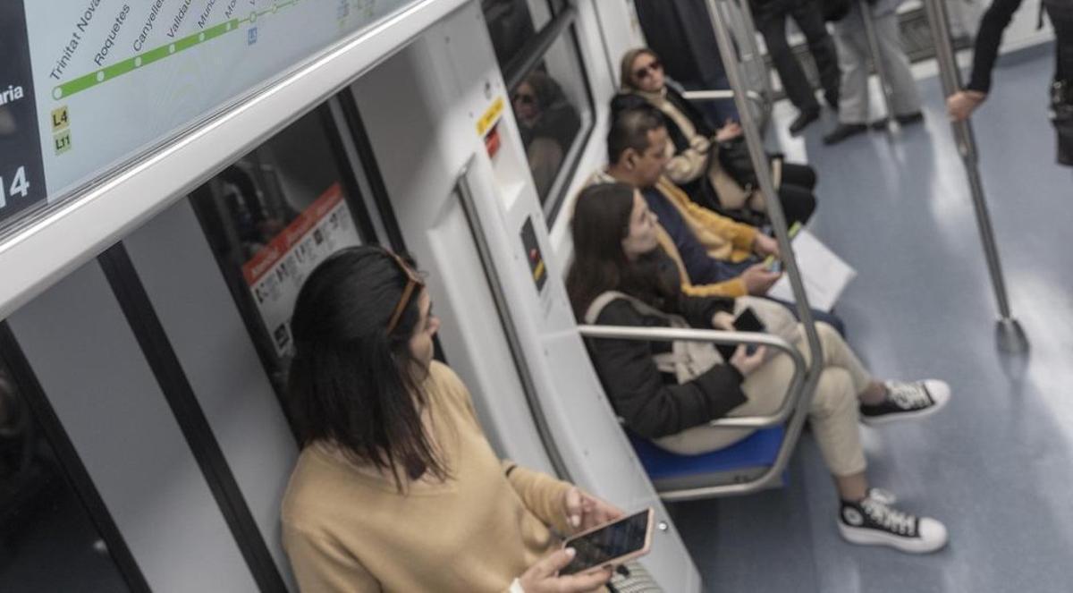 Mujer con móvil en el metro de Barcelona. Mujer con móvil en el metro de Barcelona.