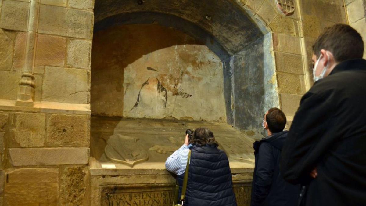 La arquéologa de la Junta supervisando el dibujo mural hallado tras la tabla, en la iglesia de San Juan. | E. P.