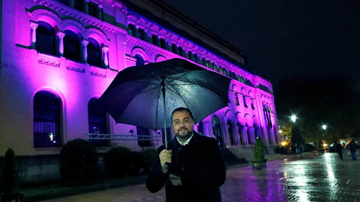 Adrián Barbón, presidente del Gobierno, posa delante de la sede de la Presidencia, iluminada de violeta.