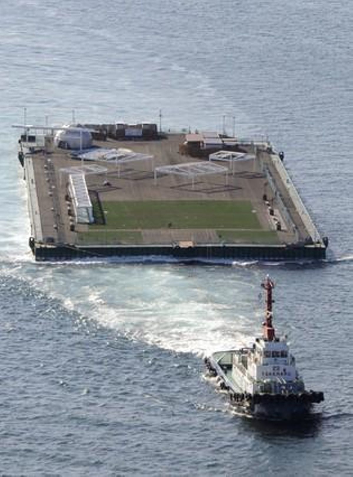 Una plataforma flotant per al tractament d’aigua és remolcada en direcció a la central nuclear, el dia 5 d’abril.