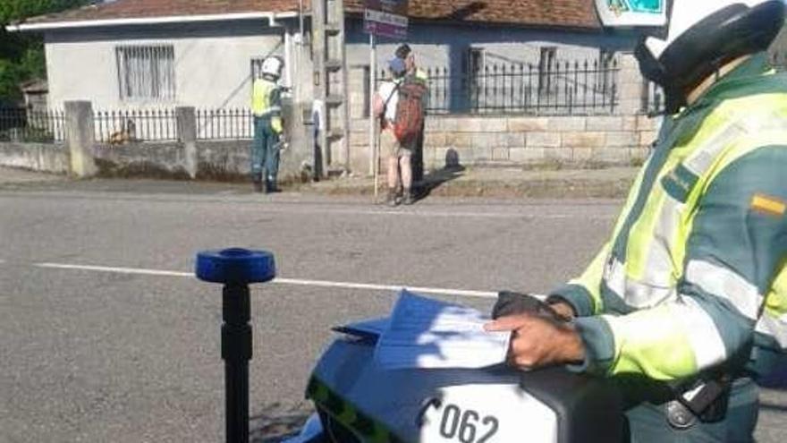 Dos agentes de Tráfico atienden a un peregrino. // OPC Pontevedra